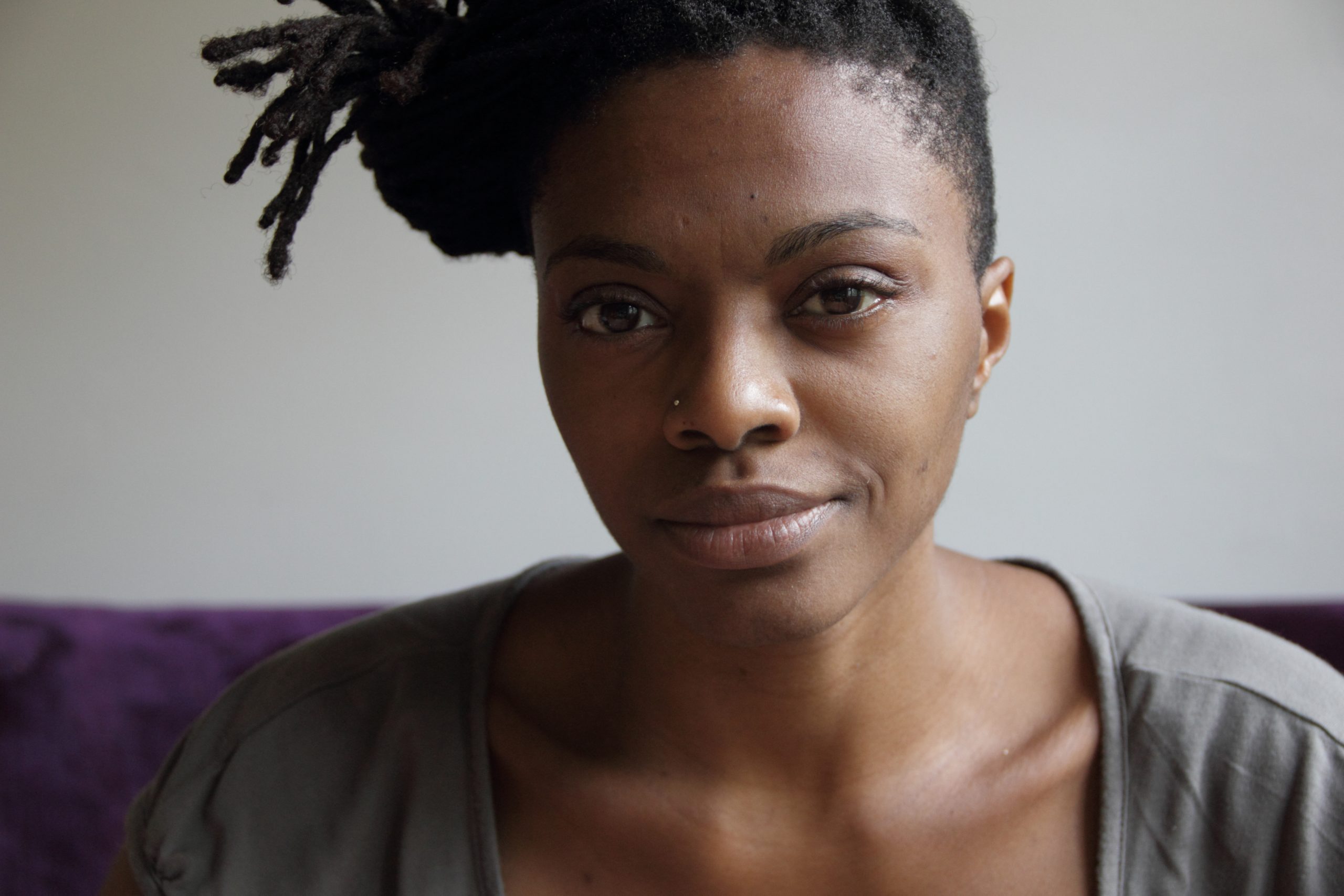 A woman with her hair up and to the side smiles at the camera